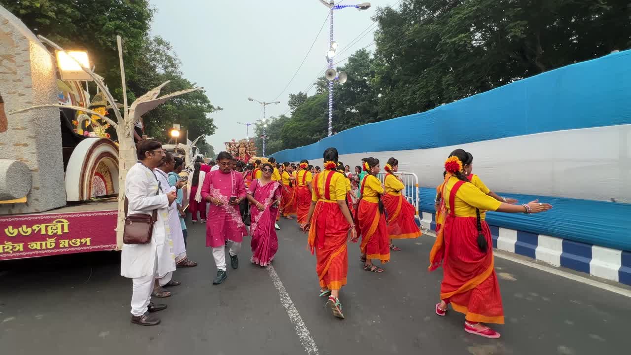 Dancers practicing for last time before performing at carnival procession in Kolkata, India. Red Road scenes.