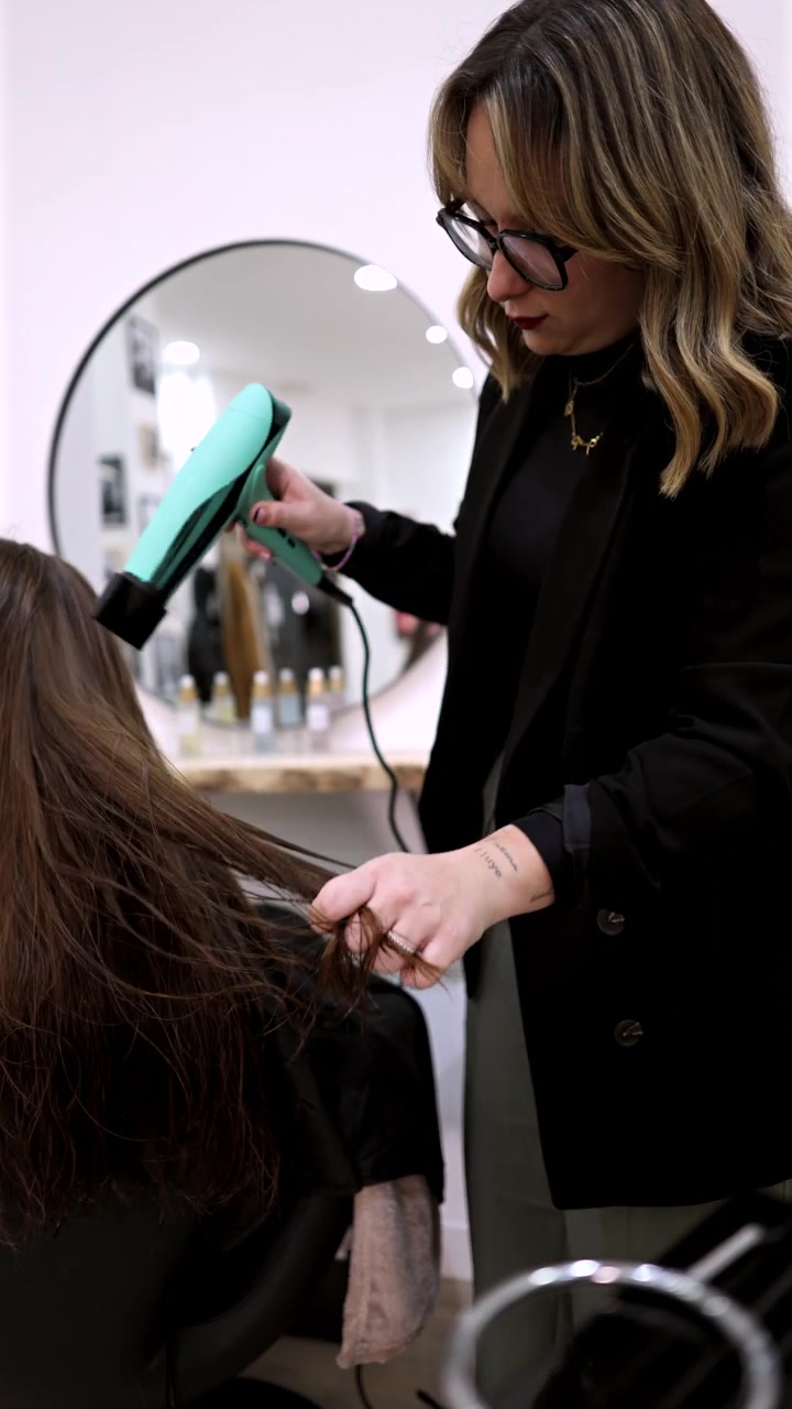 Professional Hairdresser Drying Client's Hair in Modern Salon