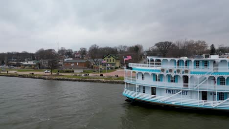 a close fly by of a paddle steamer at dock in leclaire, iowa at the beginning of winter