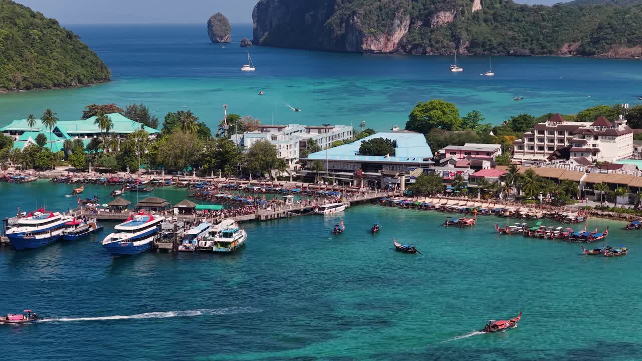 Inquadratura aerea dall'alto con angolazione elevata di barche ormeggiate al molo di un'isola tropicale in piena luce del giorno