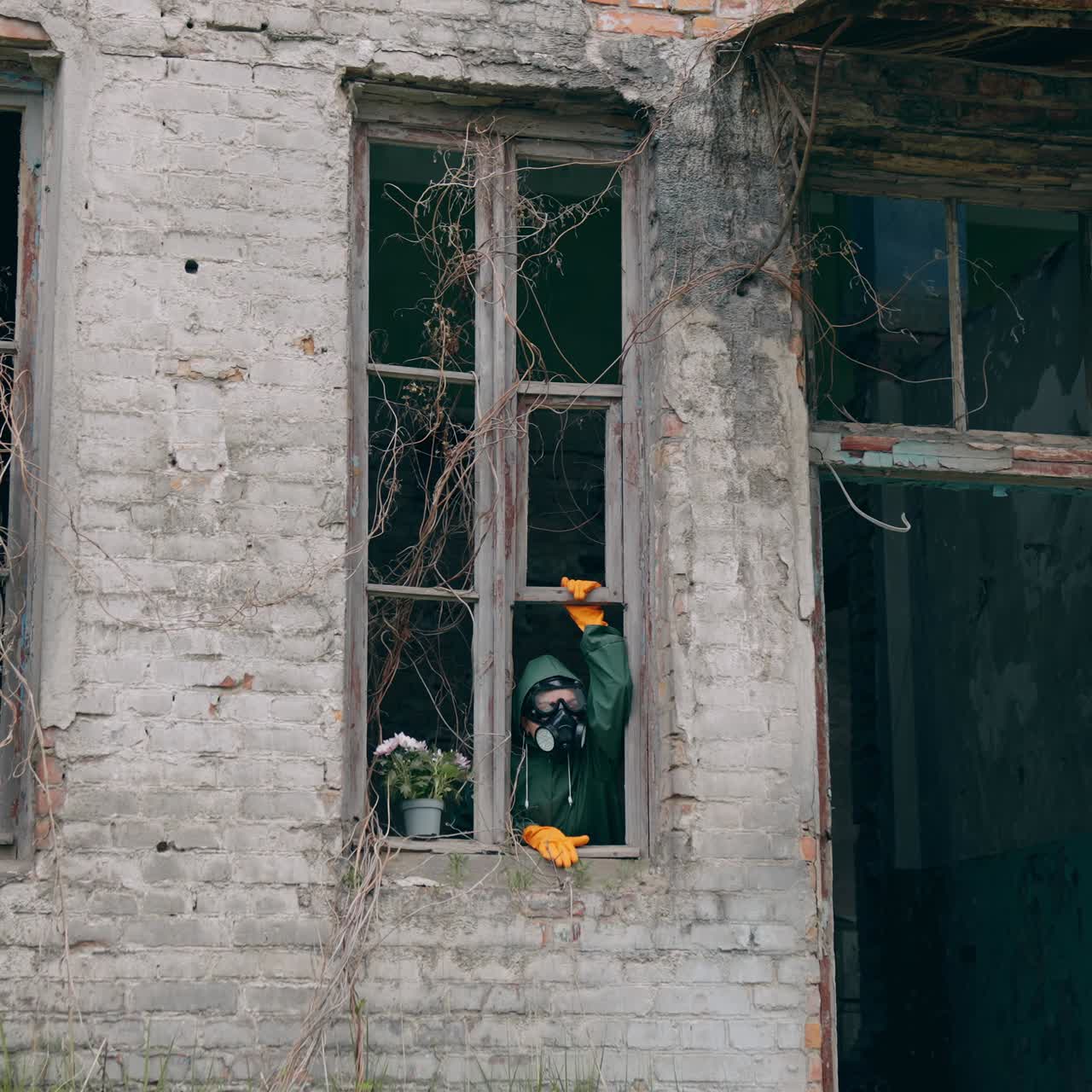 Man with gas mask in destroyed building. Man wearing protective suit and mask against radioactive environment
