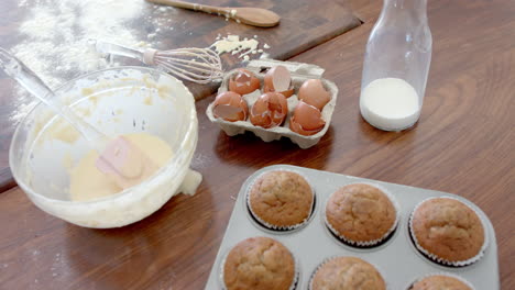 freshly baked cupcakes, mixing bowl, utensils and used ingredients on kitchen worktop, slow motion