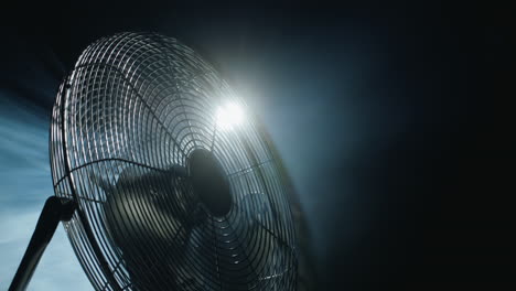 fan blades rotate in rays of light and fog