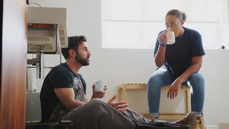 male plumber with female apprentice taking a break from fixing leaking sink in home bathroom