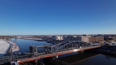 paisaje urbano aéreo de cielo azul despejado después de una tormenta de nieve con puente de acero sobre el río ijssel y llanuras de inundación blancas de la ciudad holandesa de zuitphen en los países bajos