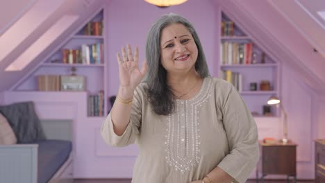 happy indian old woman waving and saying hello