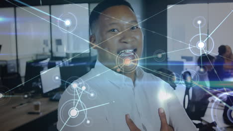 Animation-of-network-of-connections-against-portrait-of-african-american-man-smiling-at-office