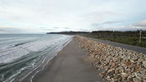 rocky sea wall between maori beach and haast highway on bruce bay in new zealand. drone shot