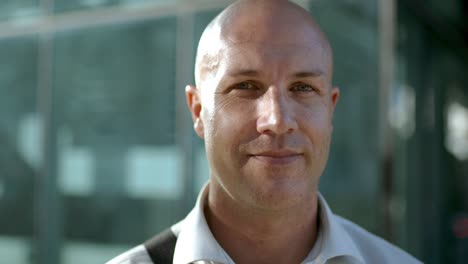 mature man with bald head looking at camera