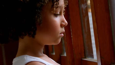 Thoughtful-African-American-schoolgboy-standing-near-window-in-basketball-court-4k