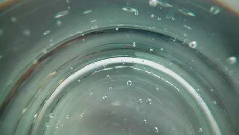 little bubbles float up inside sparkling water in glass