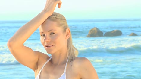 mujer rubia atractiva posando en una playa