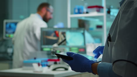 Close-up-of-chemist-nurse-using-tablet