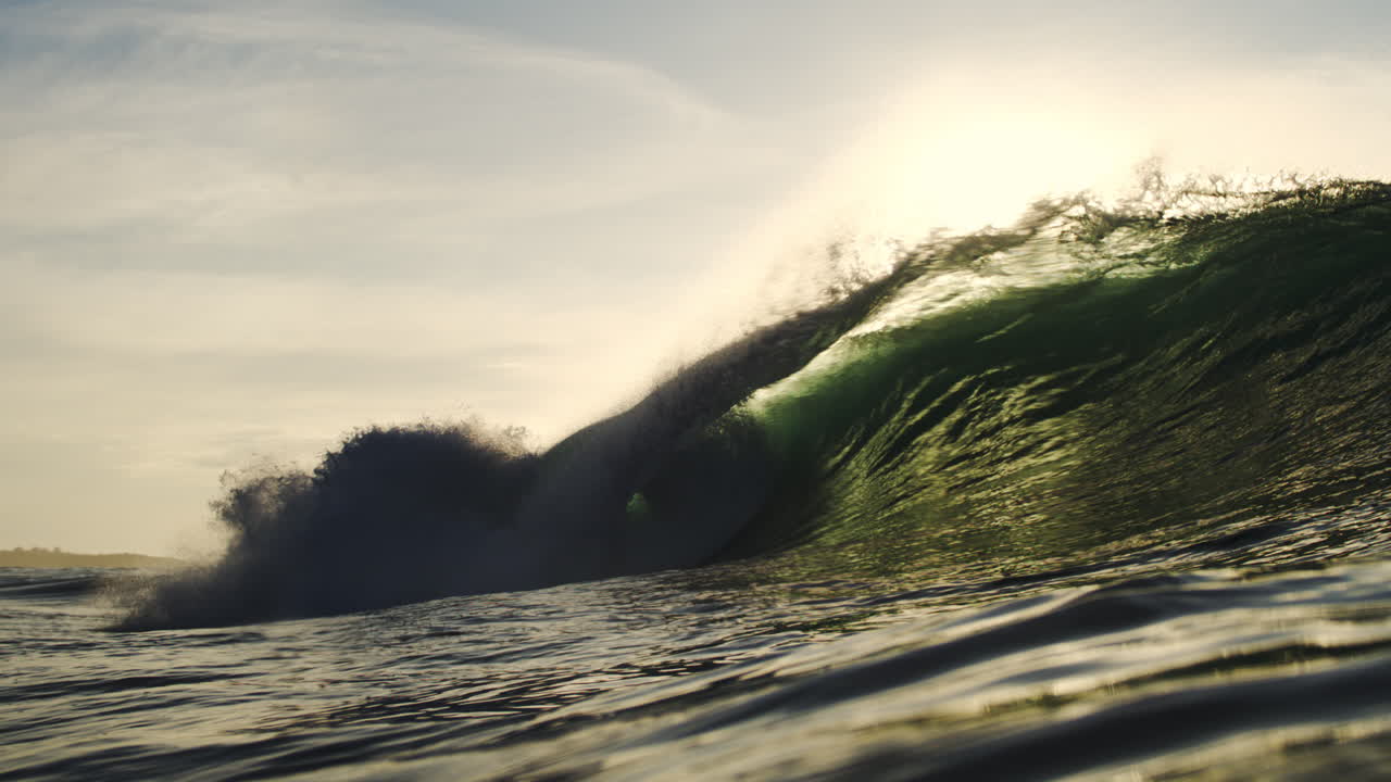Powerful Ocean Wave Breaking with Golden Sunlight and Lens Flare