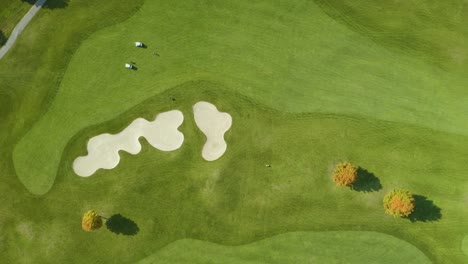 top down aerial view of golf course with sand trap in fall