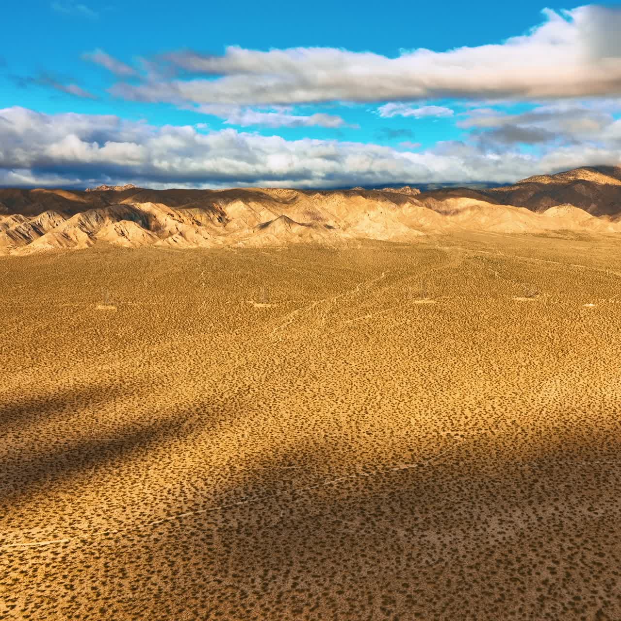 Spotted deserted landscape of Nevada on hot sunny day. Drone rising above the scenery. Rocks covered with clouds at backdrop