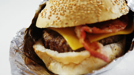 Hamburger-wrapped-in-a-foil-on-table