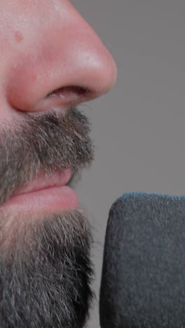 close-up of a person speaking into a microphone