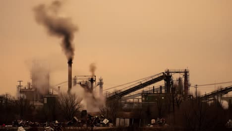 atmospheric pollution from industrial buildings emitting smoke and gases during dusk, highlighting environmental challenges and urban development issues