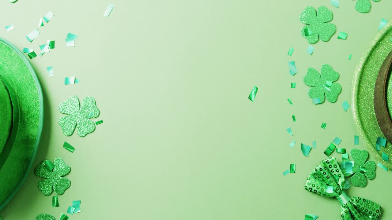 Video of st patrick's green shamrock leaves and hat with copy space on green background
