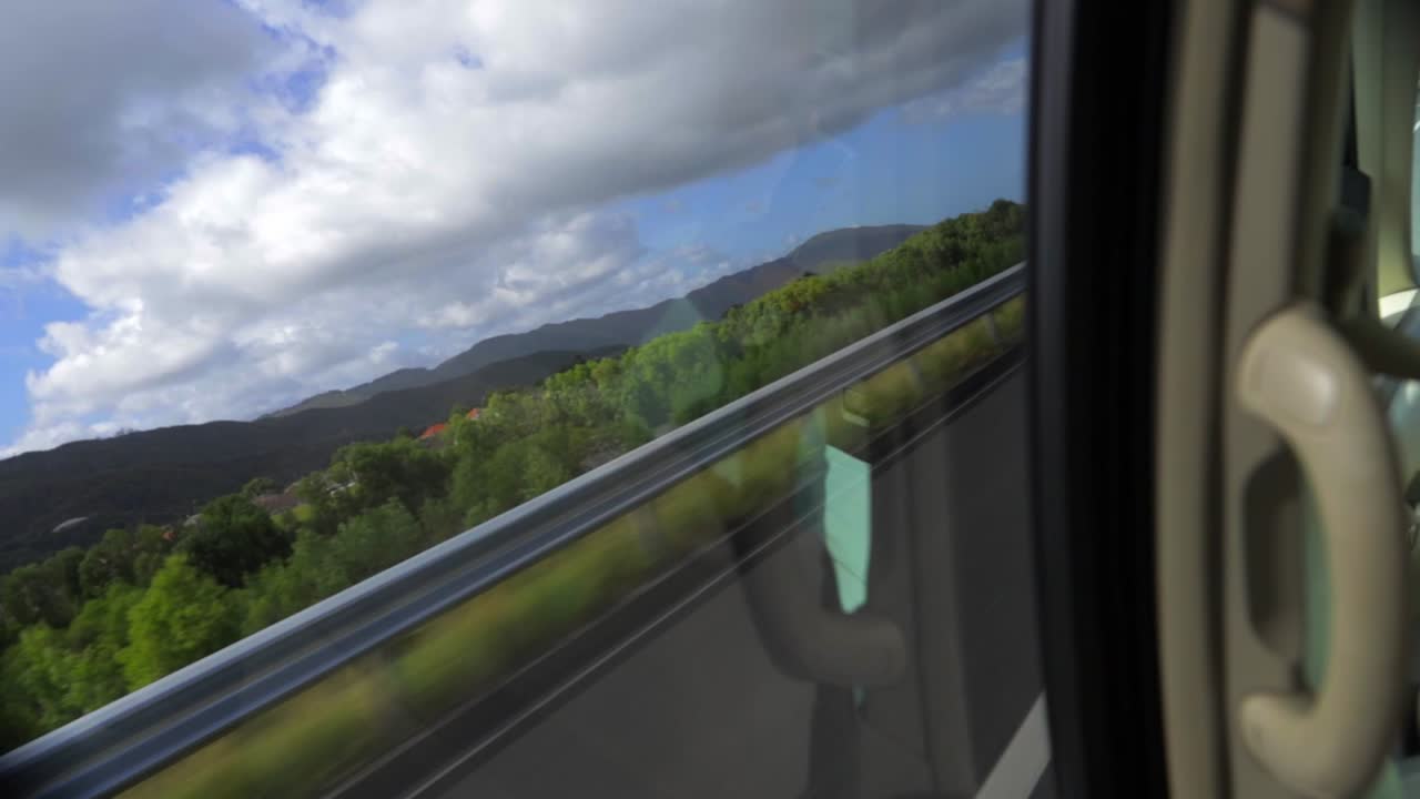 A short clip looking out of a moving vehicle onto a motorway and trees