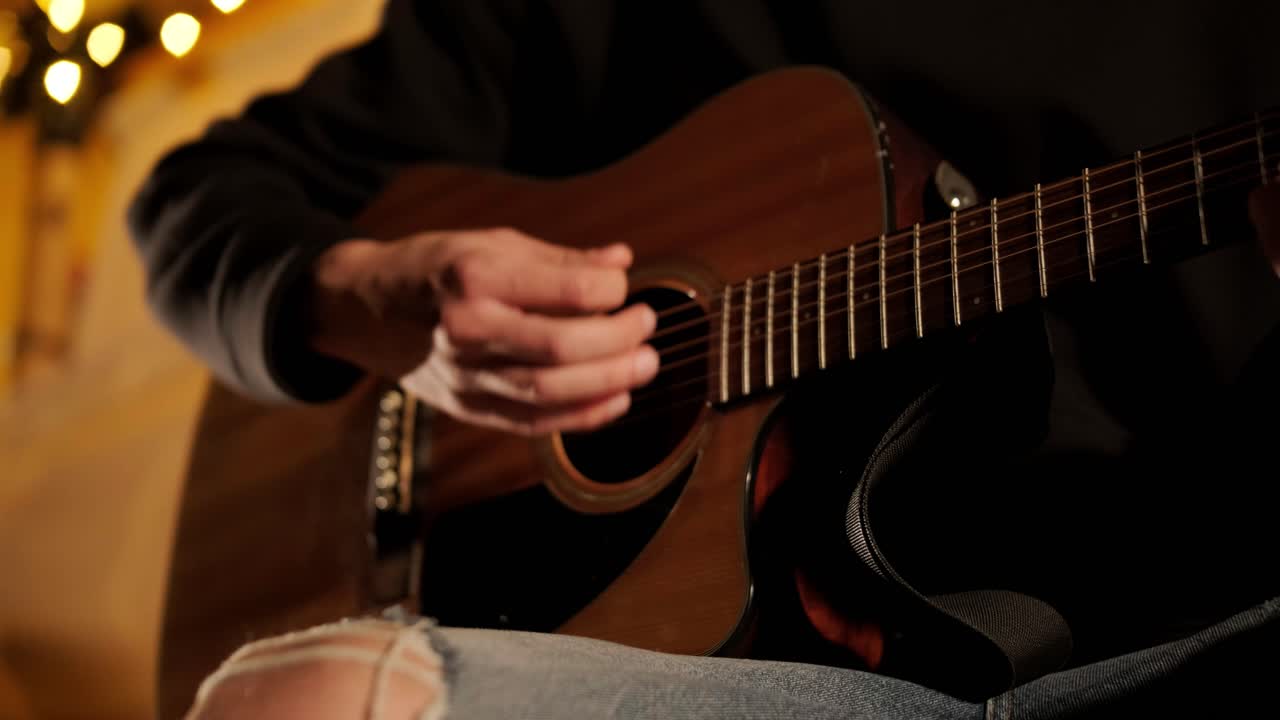 hombre toca la guitarra y canta canciones en una tienda con bombillas