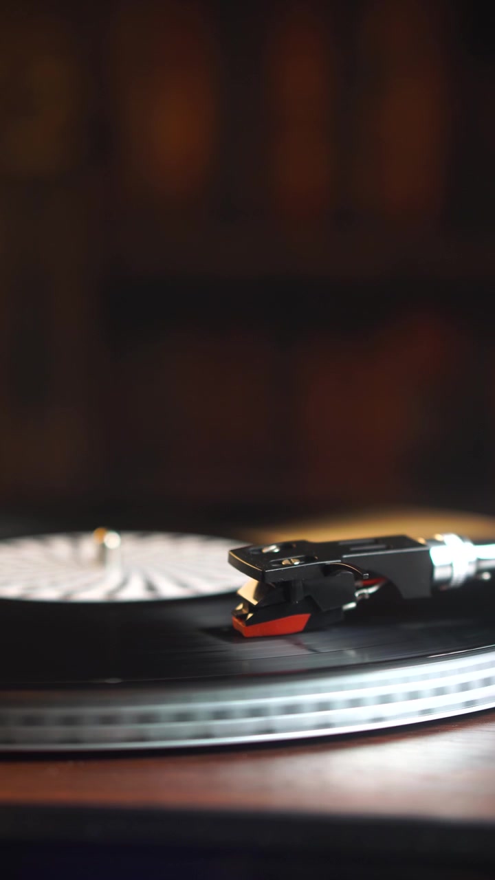 Vista verticale, puntina su disco in vinile che gira, primo piano riproduzione audio