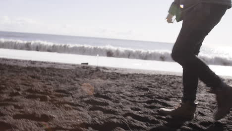 Joven-Viajero-Caminando-En-La-Playa-Negra-En-Islandia