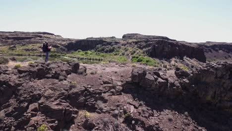 una excursionista toma una foto panorámica de la cascada salvaje de scablands coulee