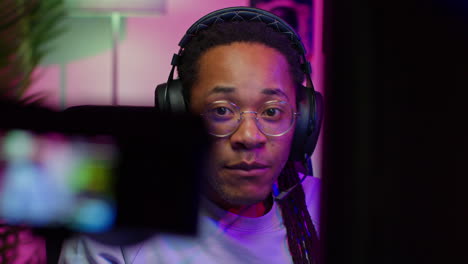 man playing video games with headphones and glasses