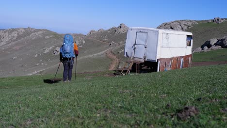 Rucksackwanderer-Geht-Am-Wohnwagen-Schlafhaus-Am-Berghang-Vorbei