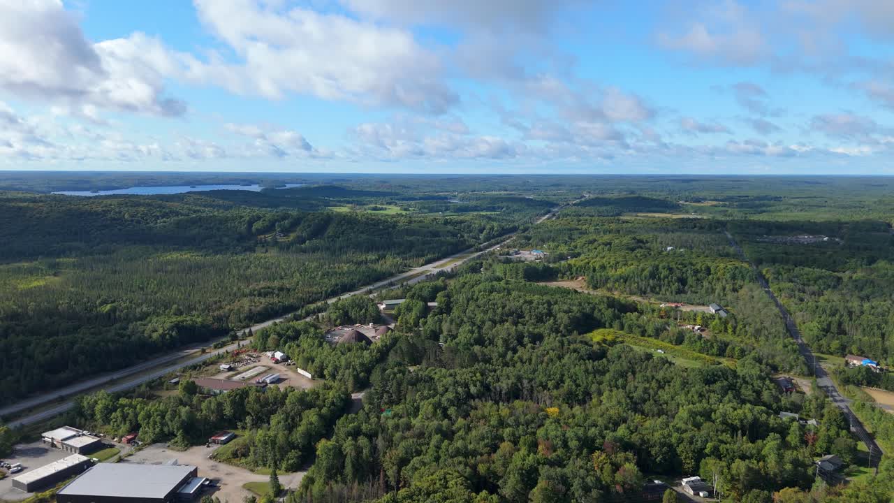 Bird’s eye aerial view of Huntsville town in Muskoka, Ontario, Canada captured on a sunny day. Showcasing town’s picturesque layout surrounded by lakes, forests, and hills