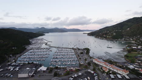 drone shot backwards over of the waikawa marina and village, dusk in new zealand