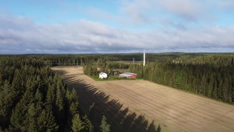 drone shot of a remote farm house surrounded by fields and forest
