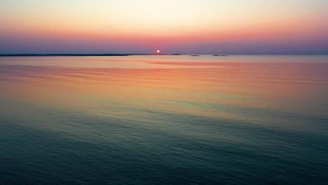 Beginn-Des-Ruhigen-Sonnenaufgangs-Am-Meer-Mit-Schwach-Beleuchteter-Sonne-über-Kleinen-Inseln-Am-Horizont