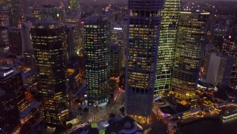 Tilting-down-aerial-view-of-a-busy-city-street-intersection-at-sunset