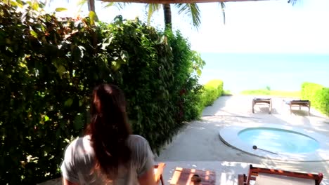 woman opening up the glass doors revealing the private pool and shore at kiwengwa