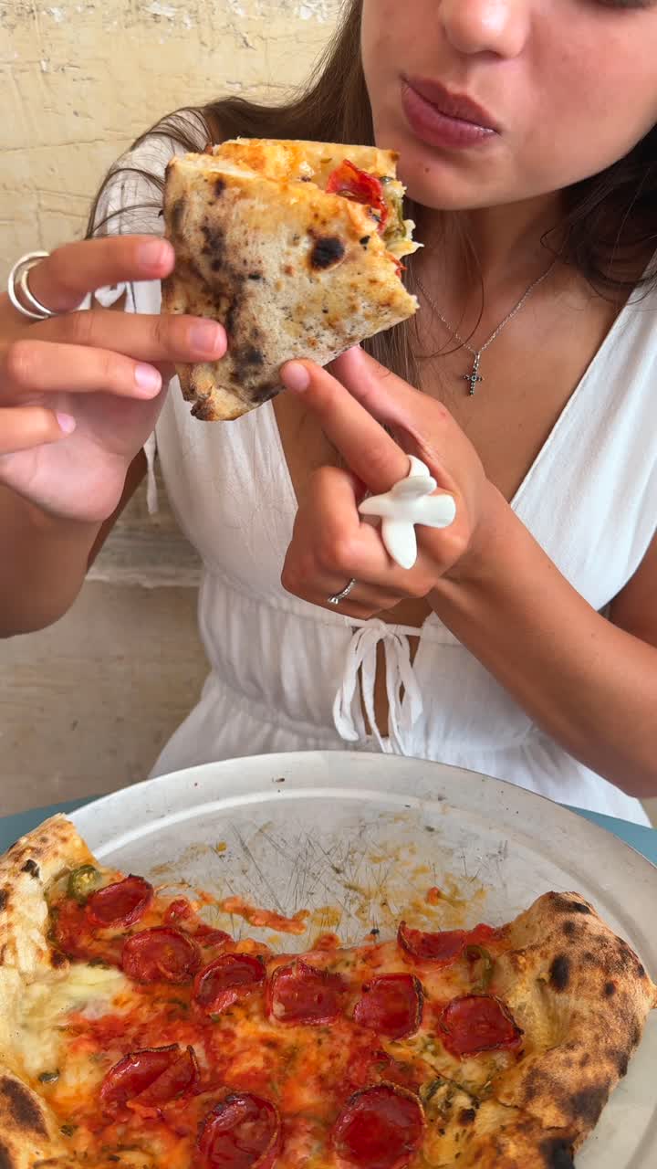 Woman enjoying a slice of pepperoni pizza