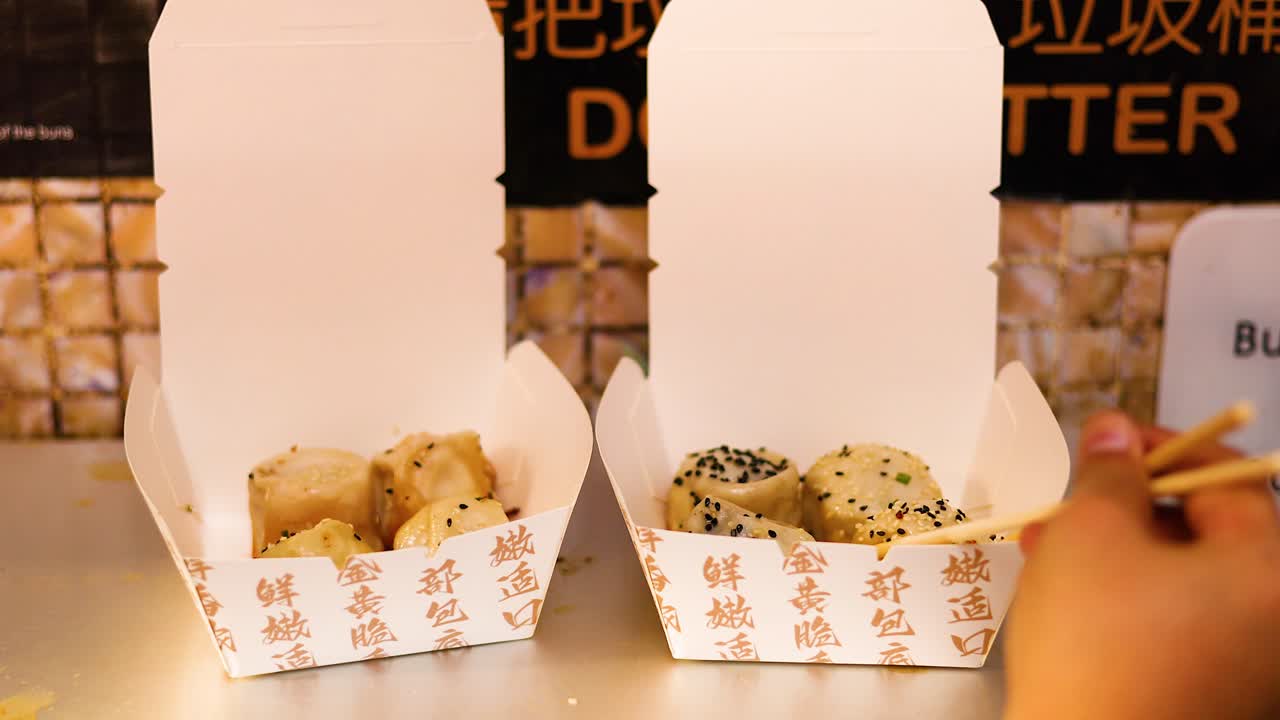 palillos para comer recogiendo panes de una caja de comida para llevar