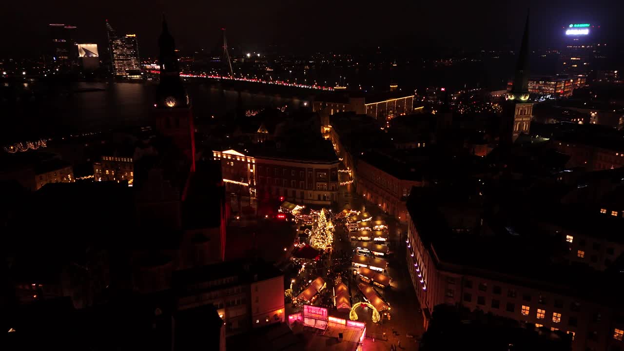 Aerial view of the Christmas Market in Riga Latvia at night showing a christmas tree and different food kiosks