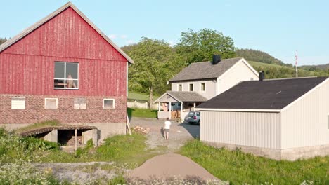 Flying-Over-Barn-House-And-Cottages-In-A-Countryside-During-Summertime