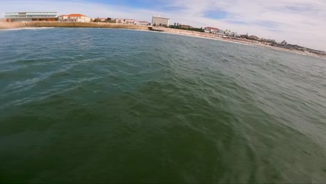 POV-Of-A-Surfer-Standing-And-Balancing-On-A-Board,-prone-Foiling-In-The-Sea-At-Summer