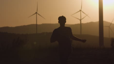 the guy runs towards the camera at sunset. silhouette shooting