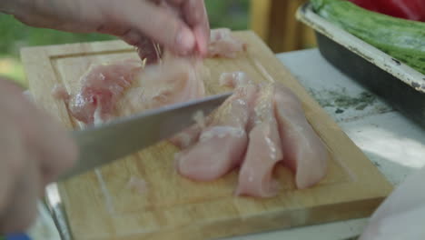 campamento al aire libre o preparación de barbacoa cortar pollo con cuchillo antes de cocinarlo