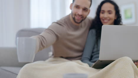 pareja feliz, café y computadora portátil en el sofá