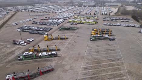 A video of a vehicle storage facility, featuring organized rows of cars, vans, and transport trucks. The scene highlights the logistics and operations of automotive distribution and storage.