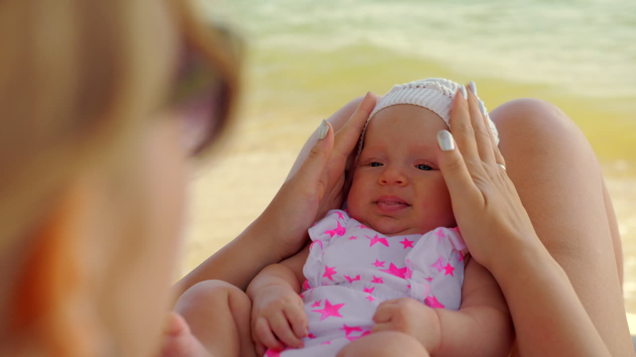 엄마와 아기가 해변에서 산책하고 있습니다.