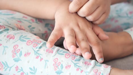 primer plano de las manos de un niño y pantalones con patrones florales
