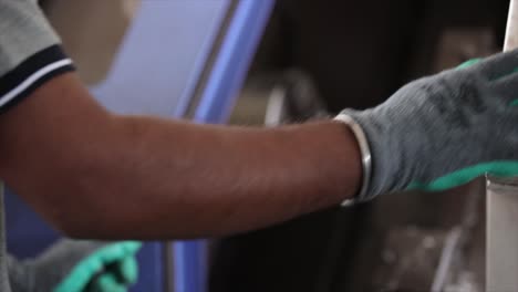 close up of a man in a factory with a metal handle