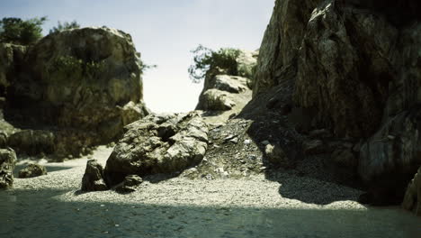 rocky beach landscape with smooth water at midday in serene natural setting